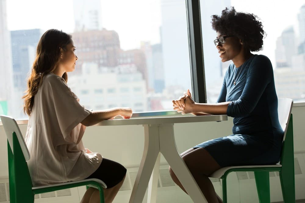 Two colleagues in an engaged discussion by a window